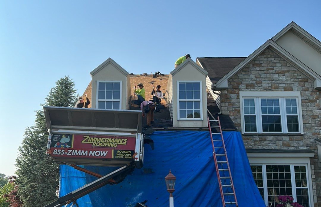 Roof replacement in progress with safety tarps by Zimmerman’s Roofing