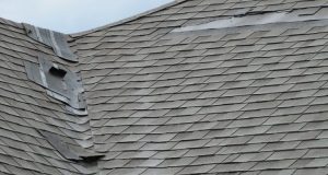 Damaged roof with peeling and missing shingles