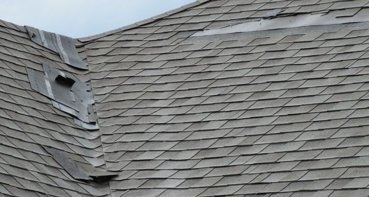Damaged roof with peeling and missing shingles
