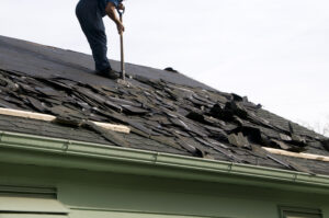 Damaged roof with many cracked, curling, and missing shingles