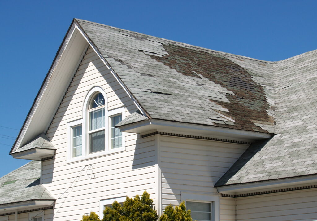 Roof with storm damage and missing shingles
